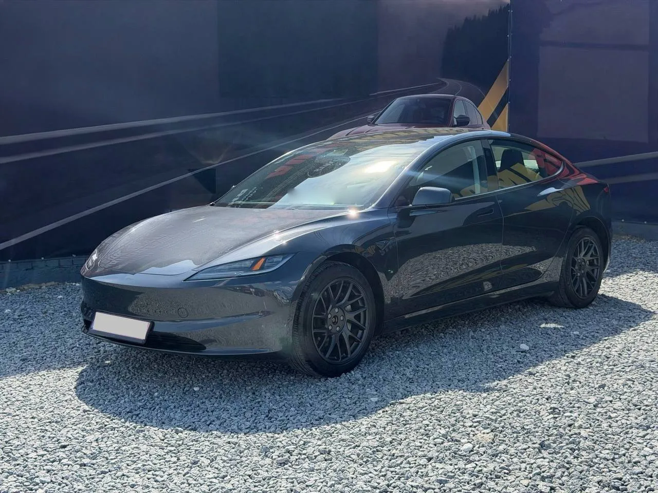 Tesla Model 3 2025 — темно-сірий седан, вигляд спереду збоку