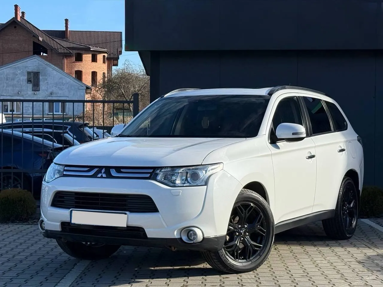 Mitsubishi Outlander 2013 — білий кросовер, вигляд спереду збоку