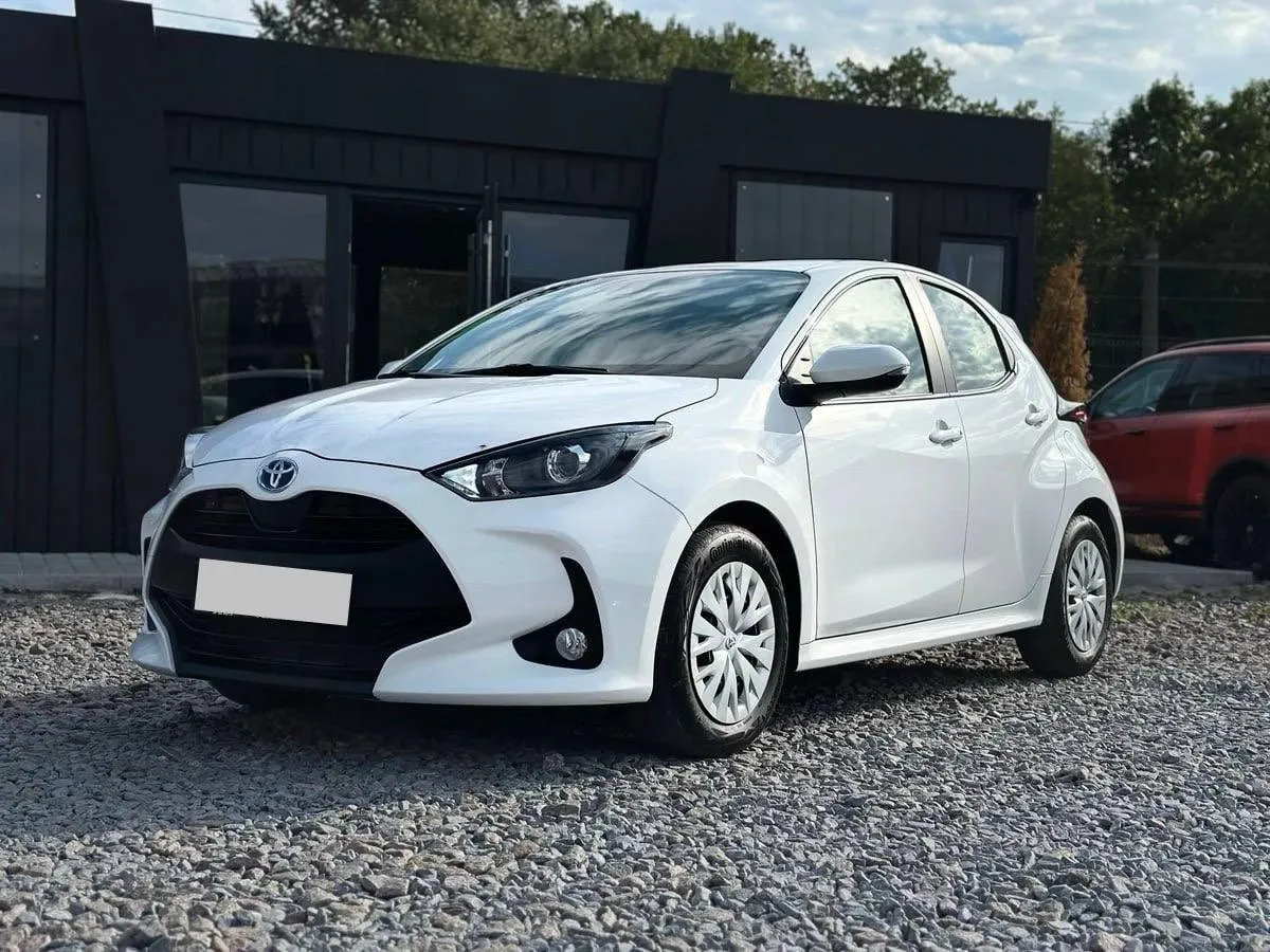 Toyota Yaris Hybrid 2023 — білий хетчбек, вигляд спереду збоку