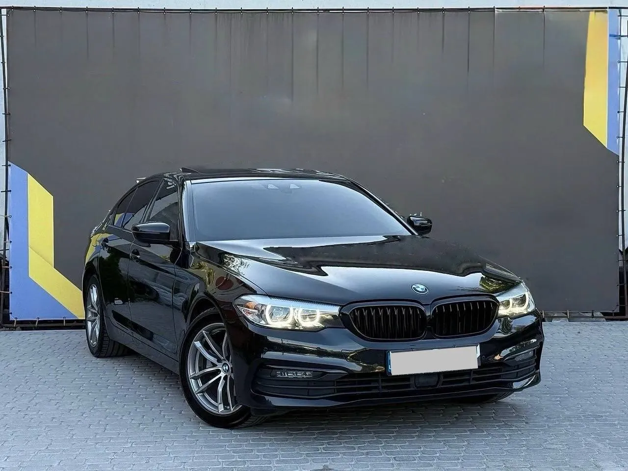 BMW 5 Series 2019 — чорний седан, вигляд спереду збоку