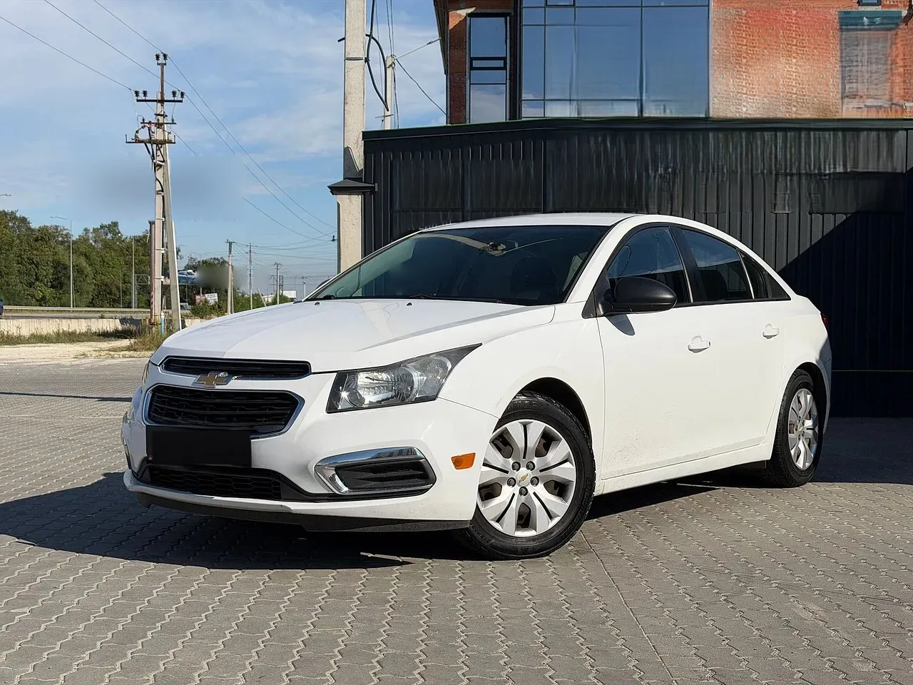 Chevrolet Cruze 2015 — білий седан, вигляд спереду збоку