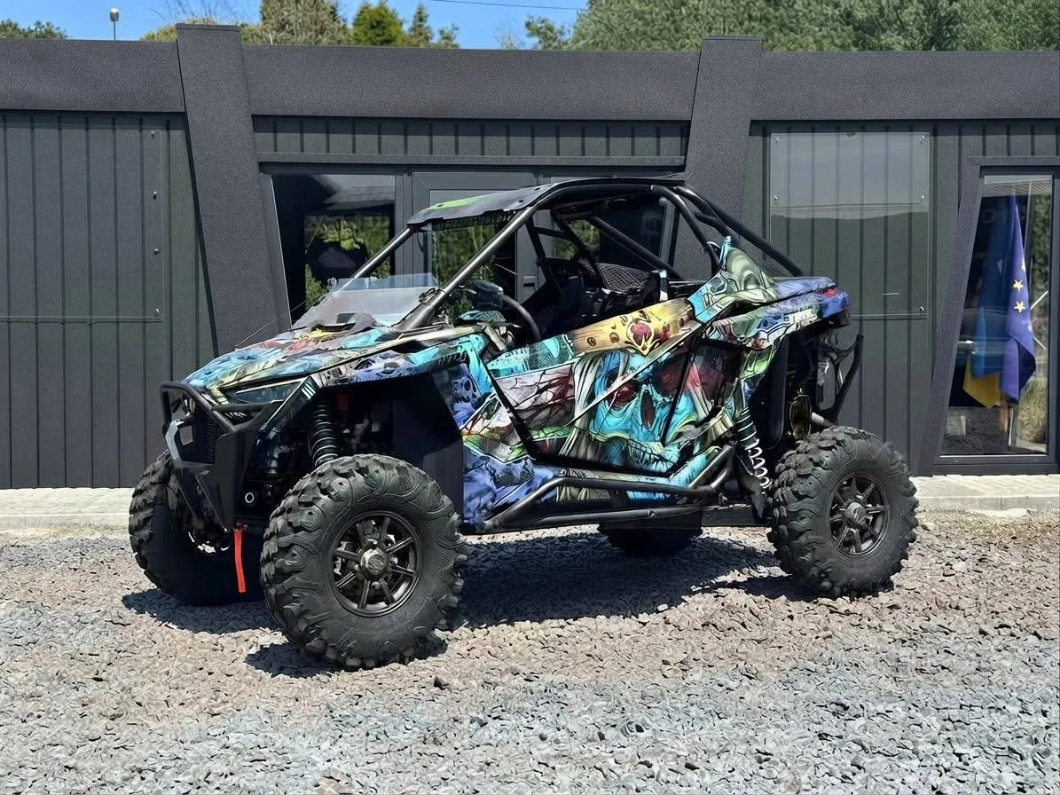 Polaris RZR Pro XP Ultimate 2024 — двомісний мотовсюдихід у кольоровій обклейці, вигляд збоку